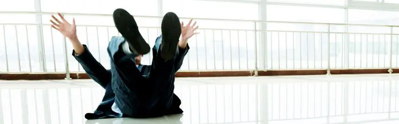 A person sitting on the ground with their hands in the air.