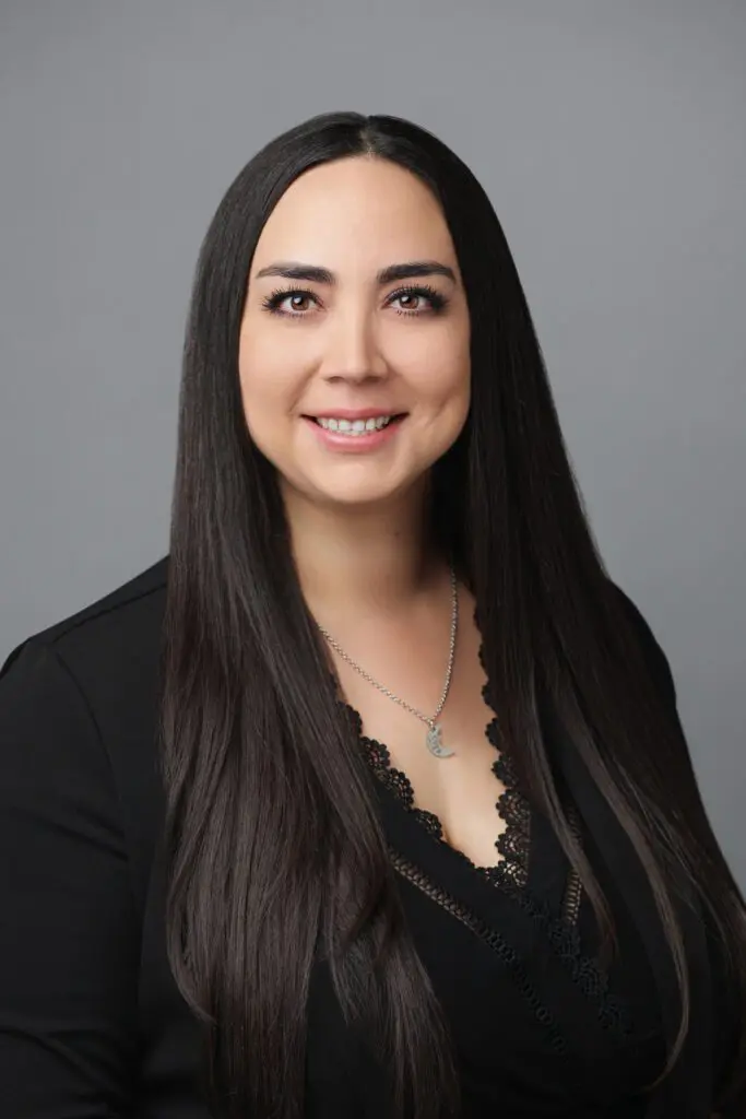 A woman with long black hair wearing a black top.