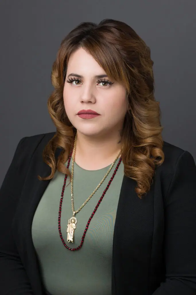 A woman with long hair wearing a necklace.