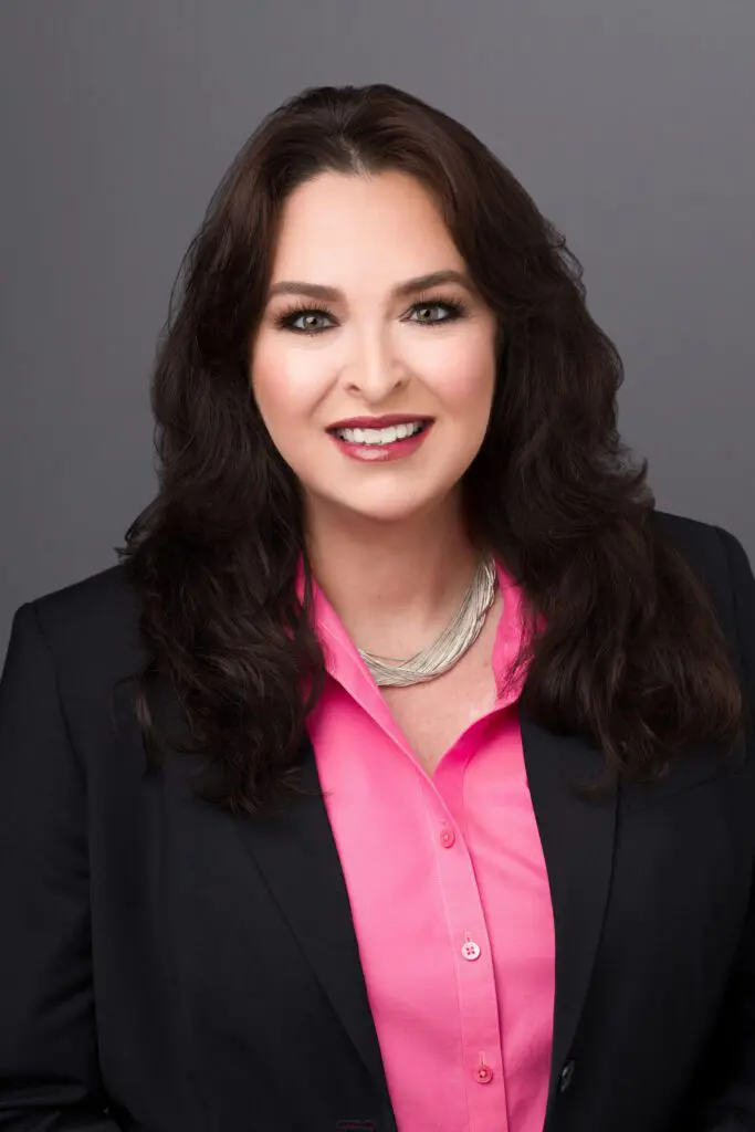 A woman in a pink shirt and black jacket