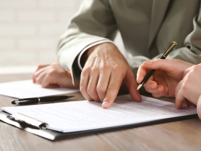 A person is writing on paper with a pen.