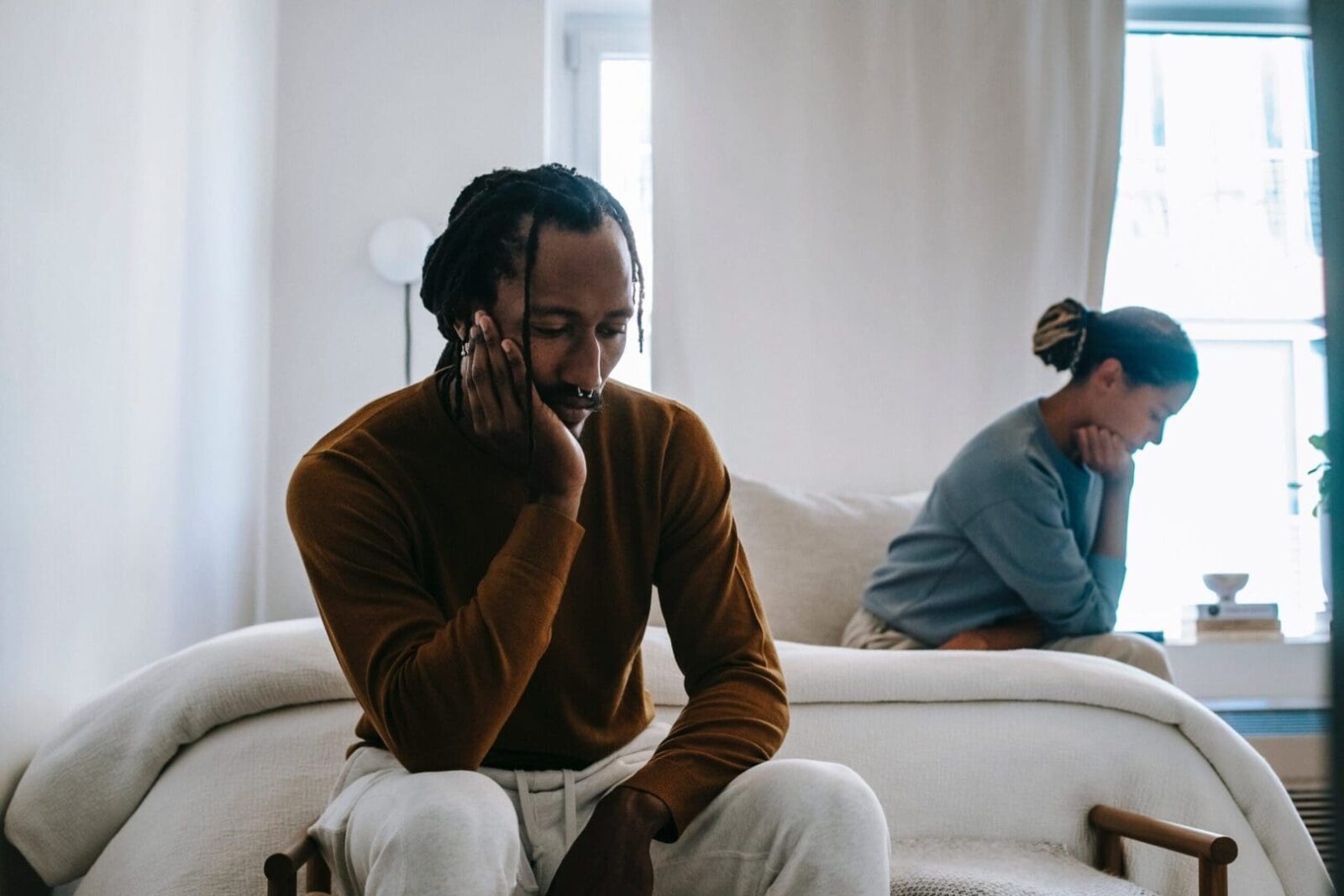 A man sitting on top of a couch next to another person.