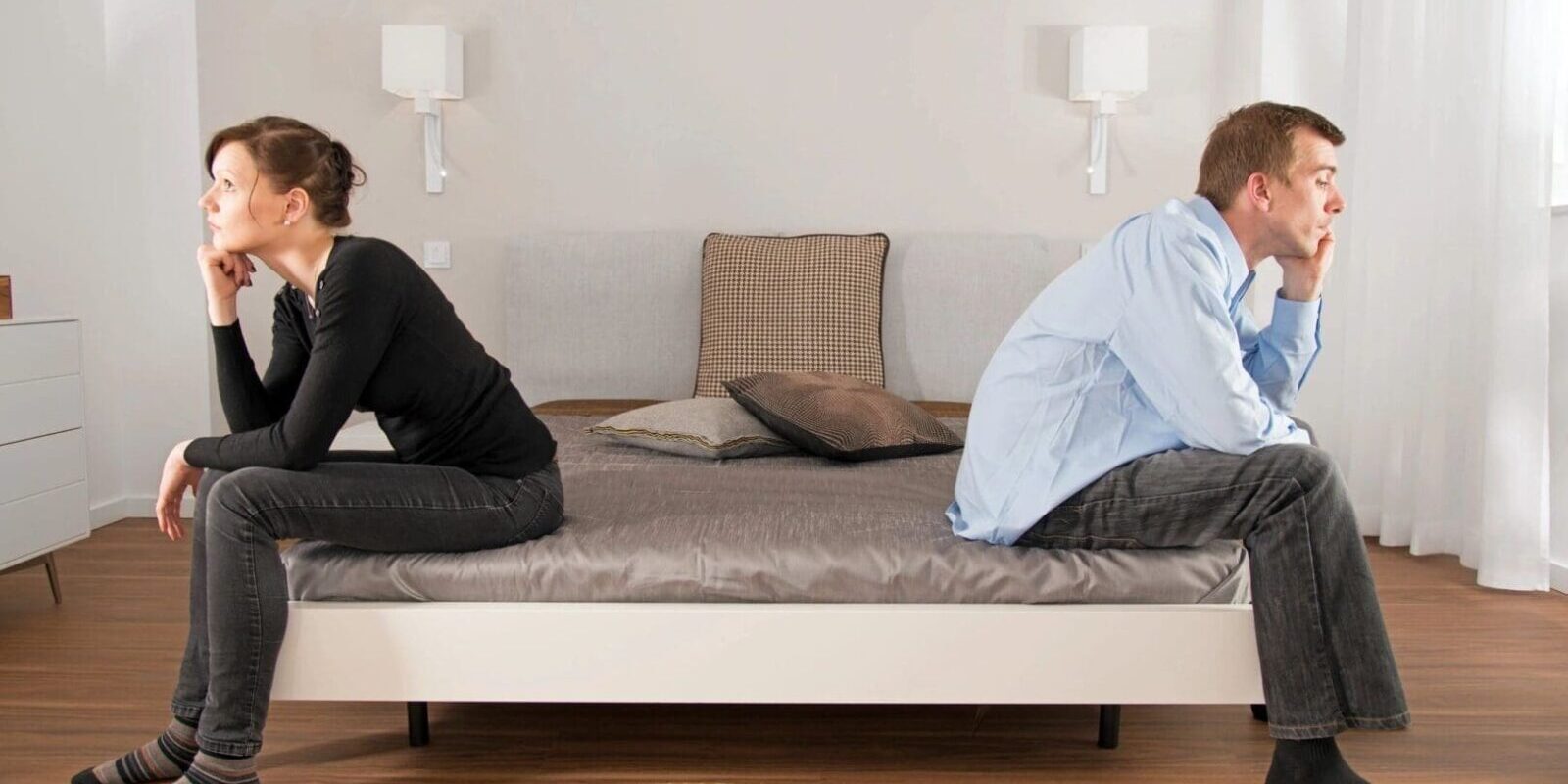 A man and woman sitting on the bed