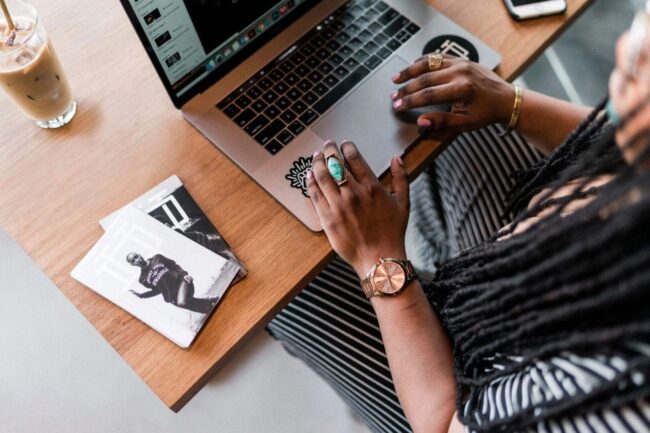 A person sitting at a table with a laptop