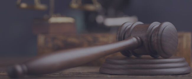 A judge 's gavel sitting on top of a wooden table.